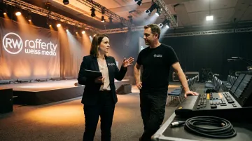 Corporate event photographer coordinating with AV crew before conference begins