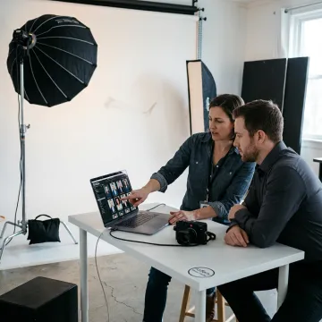 Photographer reviewing headshot images with a client