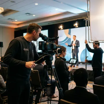 Video crew filming a conference keynote presentation