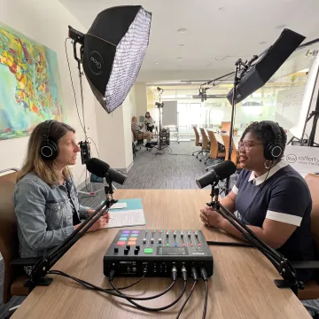 Podcast host and guest recording with studio microphones