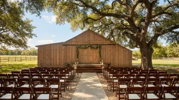 Rustic barn farm wedding venue with open pastoral landscape and outdoor ceremony setup