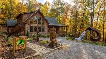Raven's Retreat Hocking Hills art lodge exterior with sculptor artwork on forested private preserve