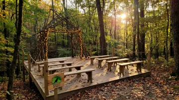 Raven's Retreat Hocking Hills elevated forest ceremony platform with rustic arch and benches