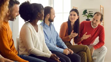 Small workplace team engaged in open conversation circle icebreaker activity