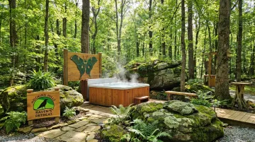 Raven's Retreat Hocking Hills private outdoor hot tub surrounded by forest art installations