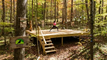 Raven's Retreat Hocking Hills forest ceremony platform surrounded by trees and sculptures