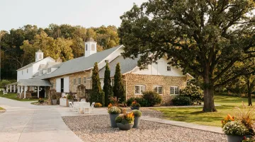 Rustic stone barn estate wedding venue with historic architecture and mature oak tree