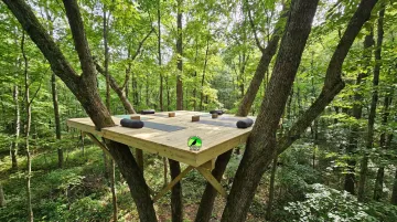 Elevated wooden yoga platform set into forest canopy at Raven's Retreat Hocking Hills