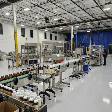 Professional supplement bottle packaging line with labeling and sealing equipment in Denver facility
