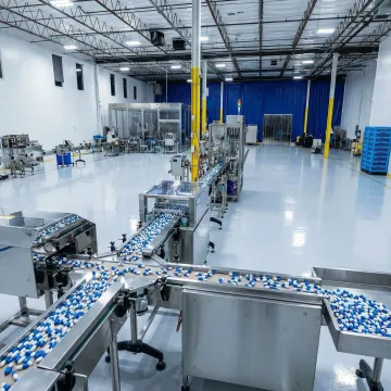 Modern pharmaceutical manufacturing facility producing delayed-release capsules with automated equipment