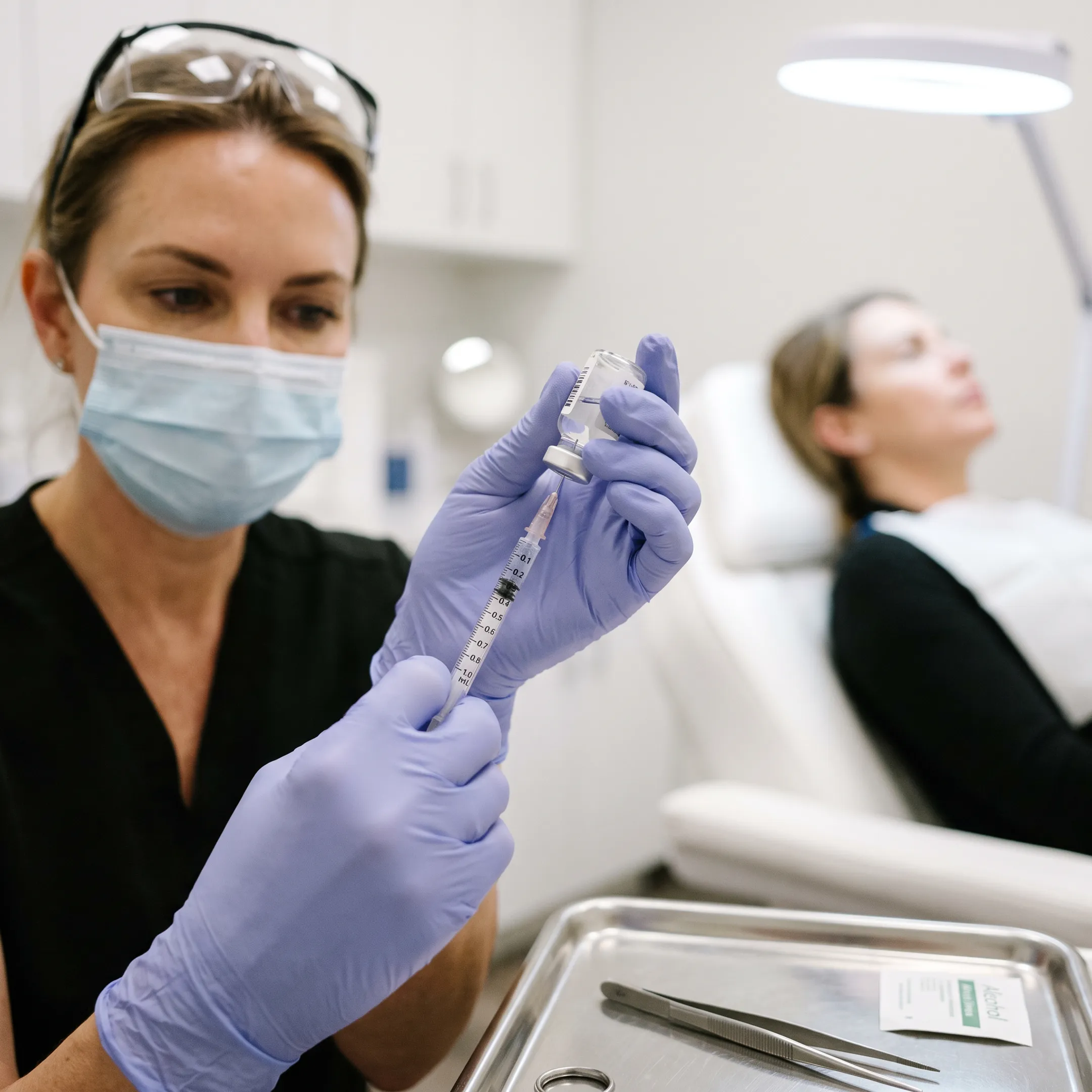 Aesthetic nurse injector preparing neuromodulator injection for lip treatment