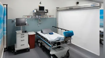 Rolascreen retractable medical privacy screen deployed in hospital patient room beside bed