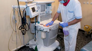 Healthcare worker disinfecting stethoscope and blood pressure cuff between patient contacts