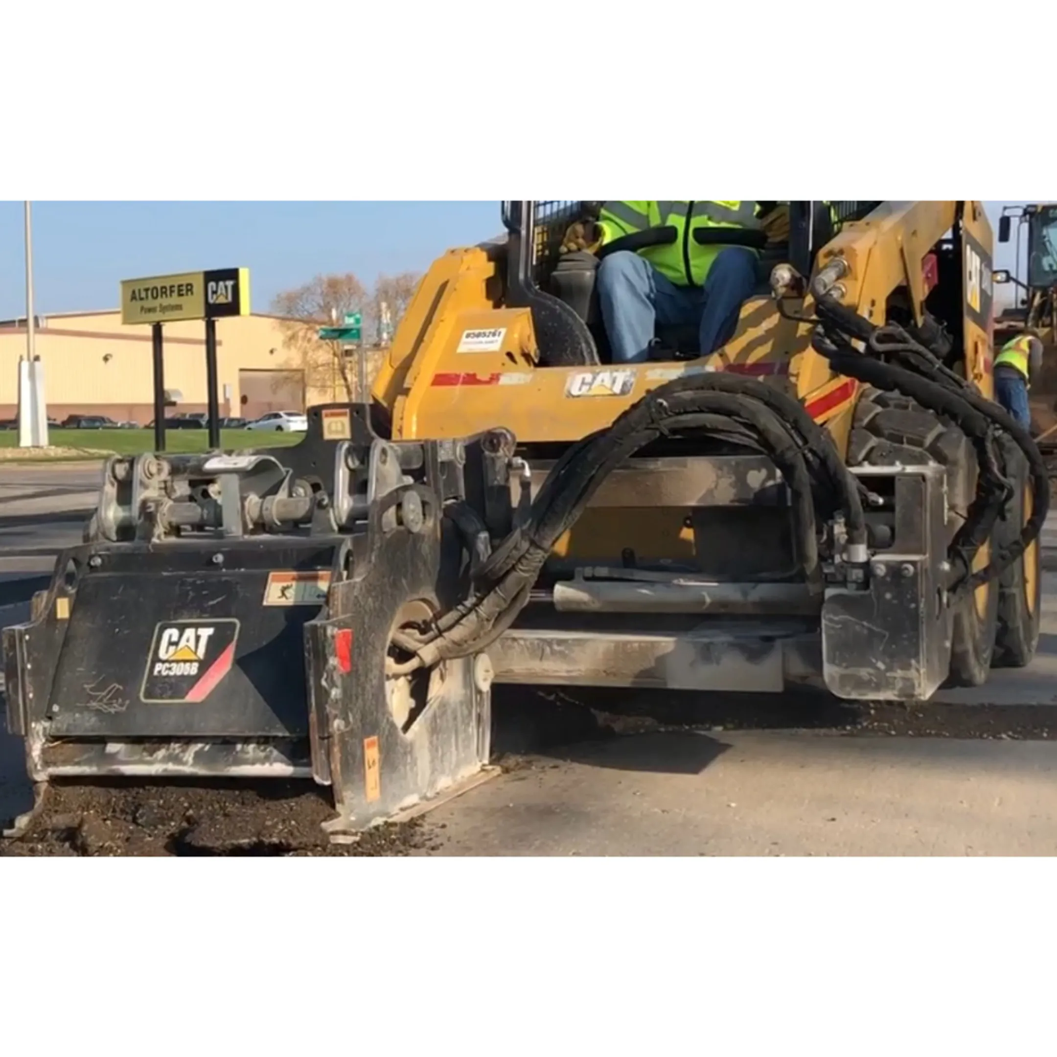 Skid steer milling a paved surface