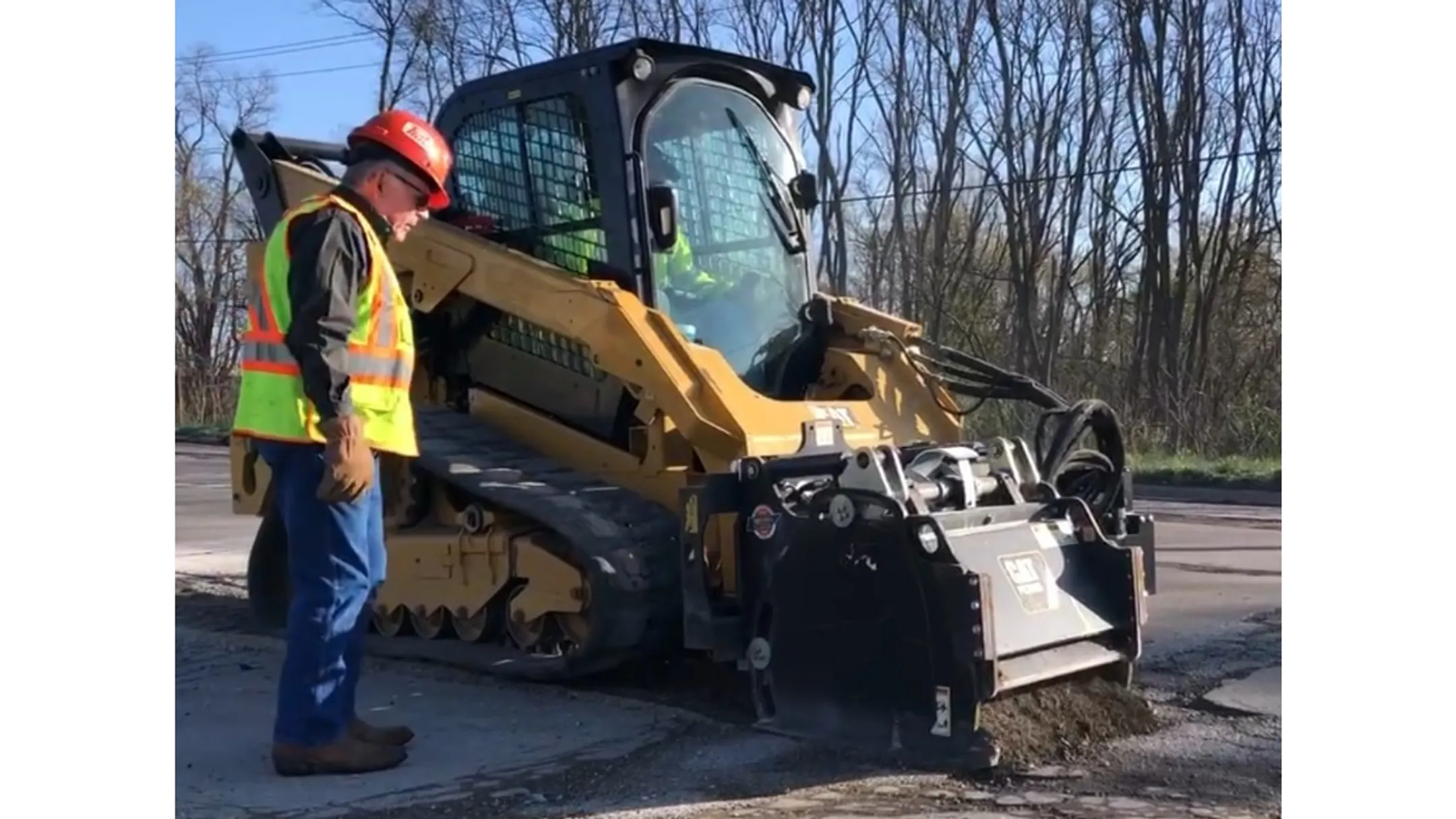 Dump truck delivering asphalt millings to construction site for grading