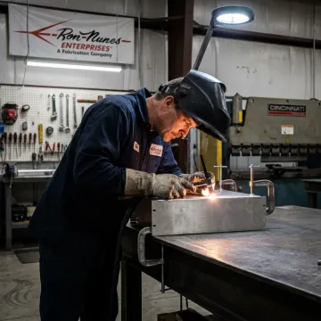 Welder fabricating metal assembly
