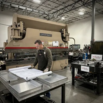 Fabricator reviewing sheet metal enclosure drawings