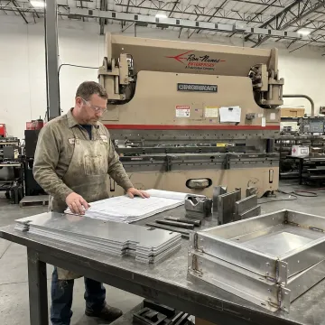Technician reviewing fabrication drawings