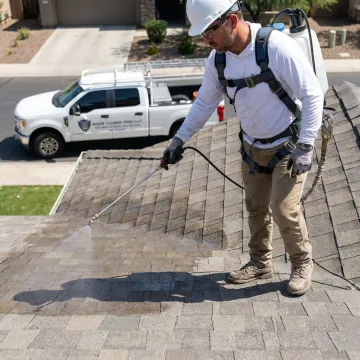 Roofing contractor applying protective treatment to shingles