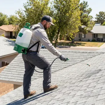 Roofer applying protective treatment to shingles