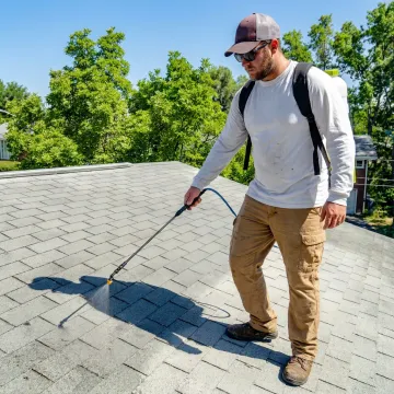 Technician applying roof preservation treatment