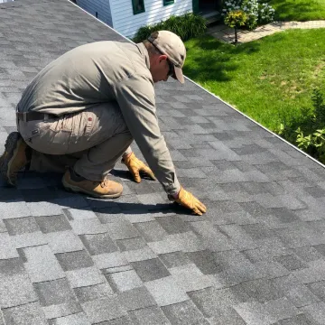 Roof specialist inspecting residential shingles