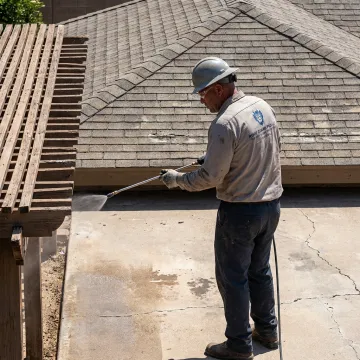 Technician applying protective coating to exterior surface