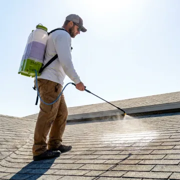 Technician applying protective coating to an Arizona roof