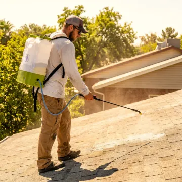 Technician applying protective roof coating