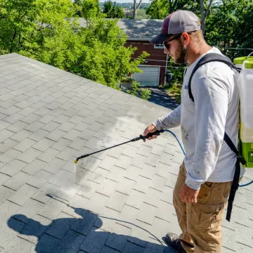 Technician applying roof renewal coating