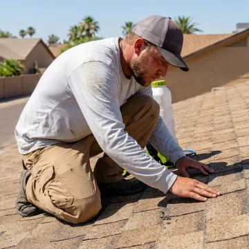 Technician inspecting an Arizona shingle roof