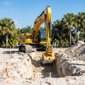 Large excavator performing land excavation work on a South Florida construction site