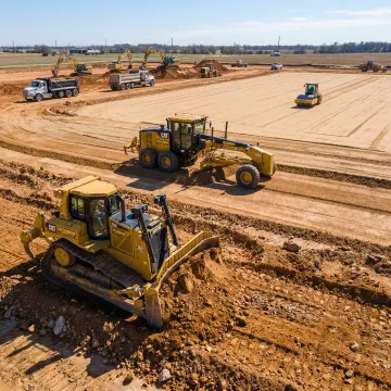 Construction site showing systematic grading process with excavation equipment