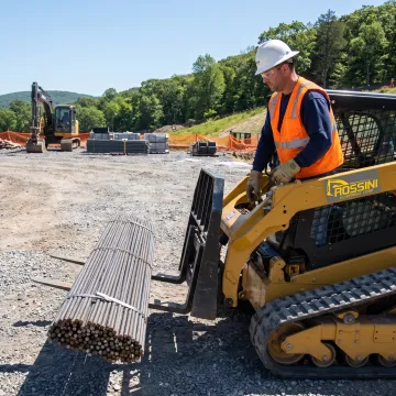 Equipment operator using forklift forks at a jobsite