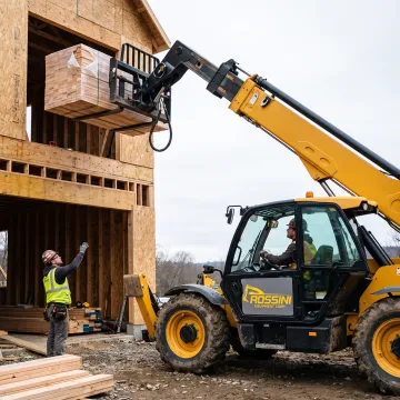 Telehandler placing materials at an elevated work area