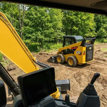 Heavy construction equipment including excavators and skid steers at a Forestburgh NY job site