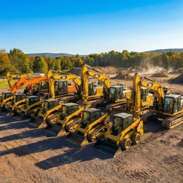 Heavy construction equipment including excavators and skid steers at Highland NY job site