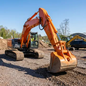 Excavator operating on a construction site with operator in cab