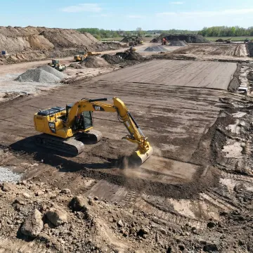 Mass grading operation showing excavator shaping large building pad