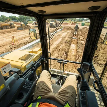 Excavator operator performing precision site grading work