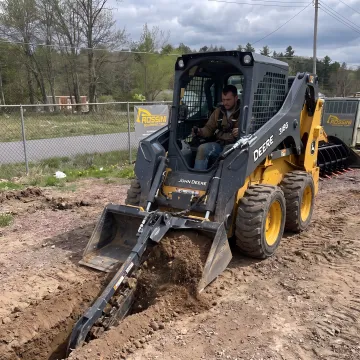 Operator using a skid steer bucket