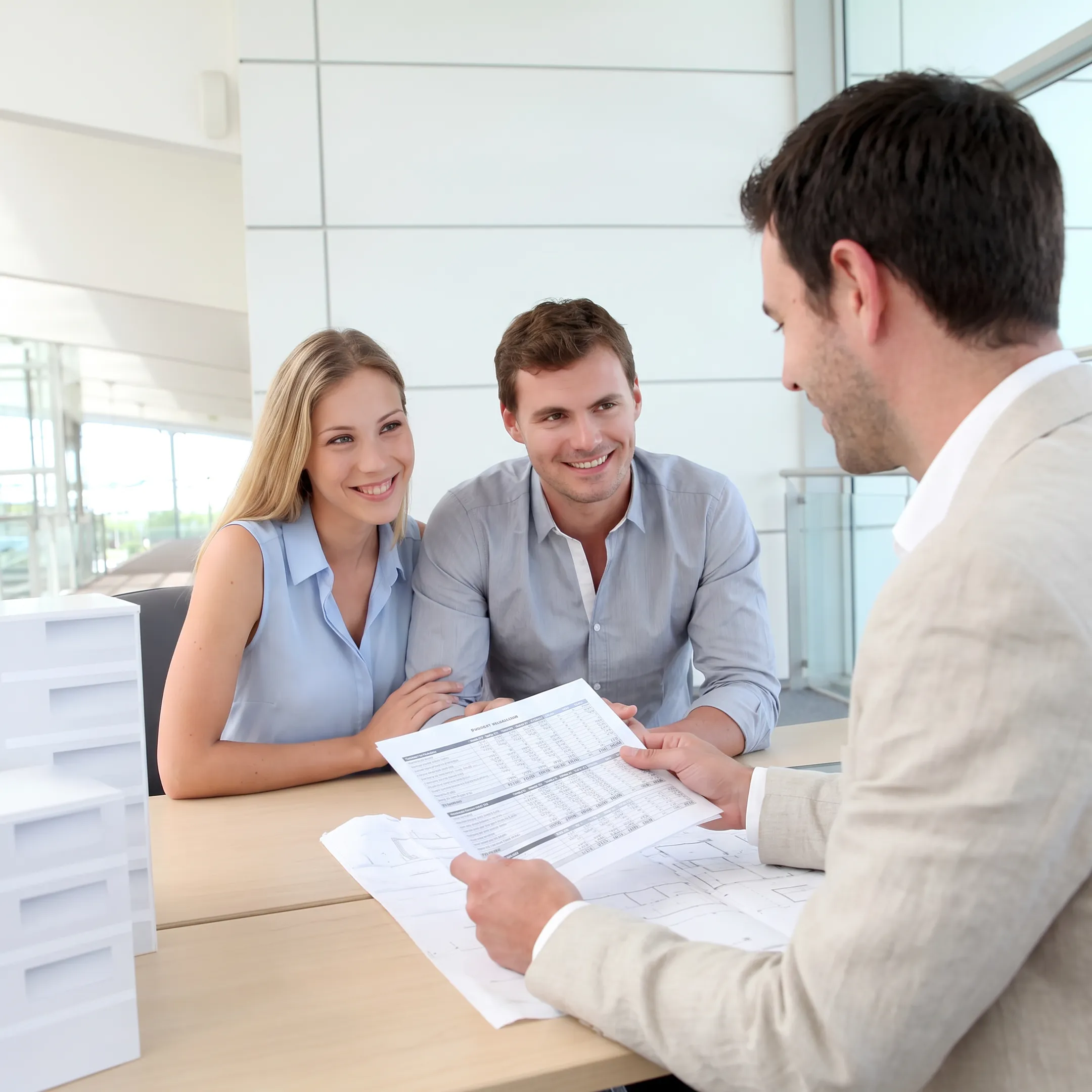 Business broker reviewing company financial documents with an entrepreneur at a conference table