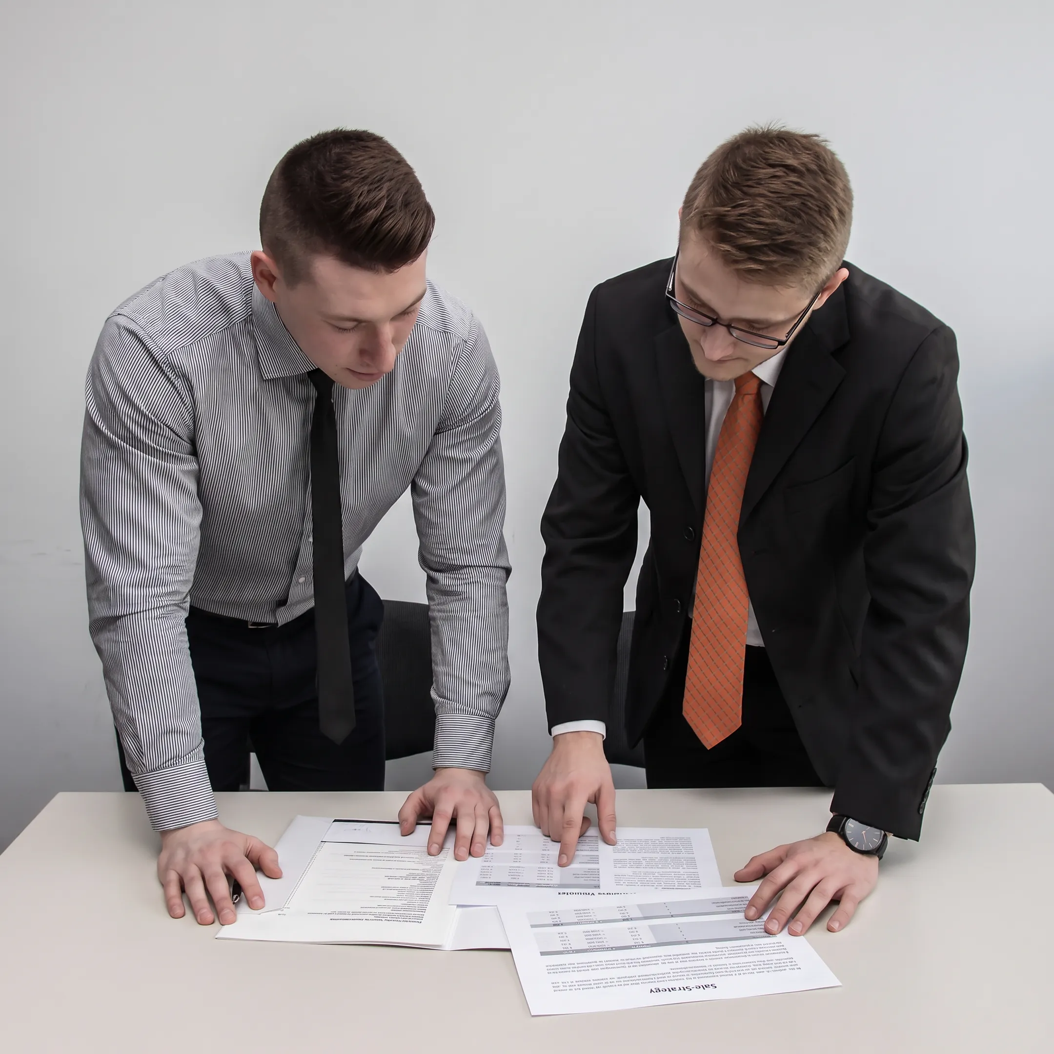 Business broker reviewing confidential company sale documents with an owner