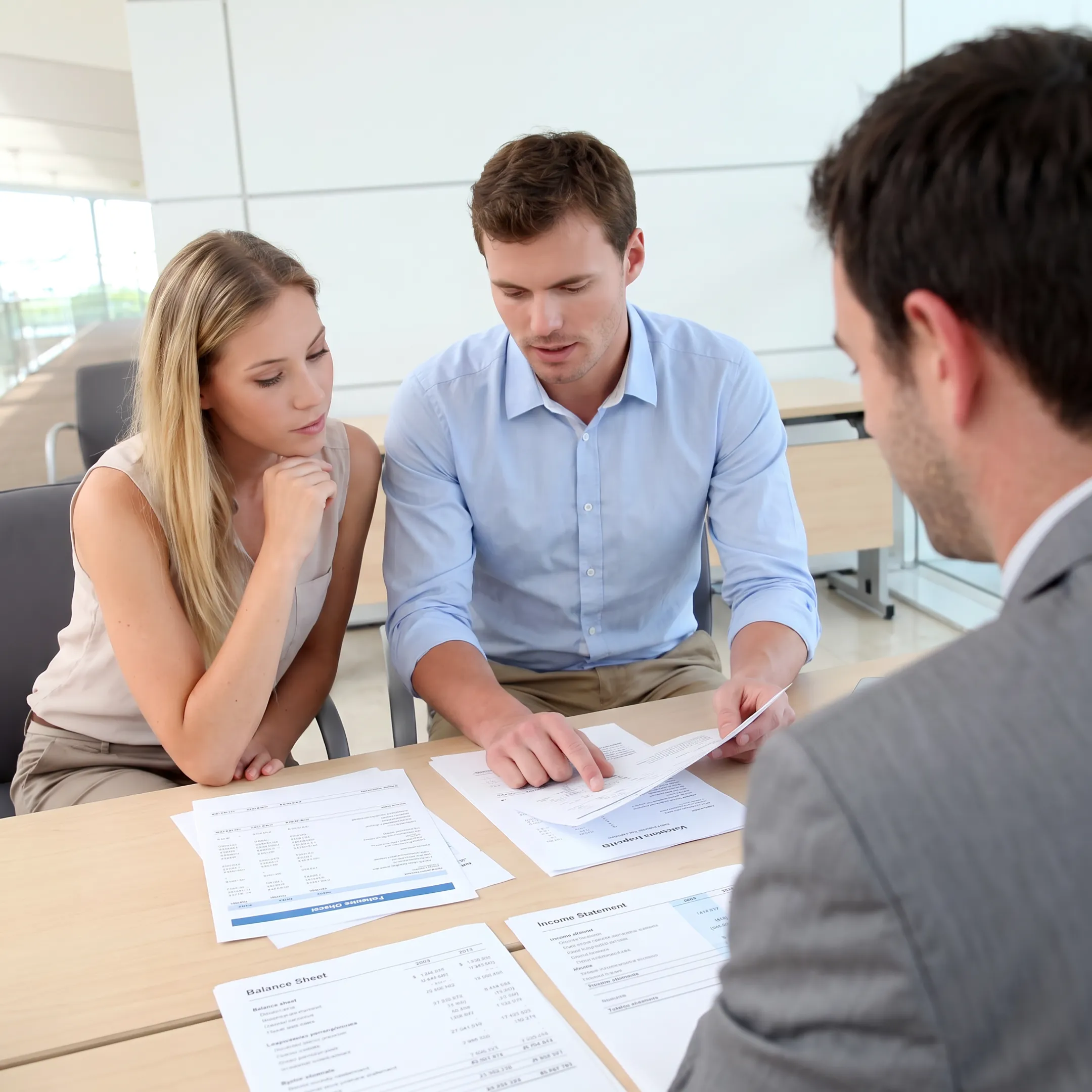 Business broker reviewing company documents with an owner at a conference table