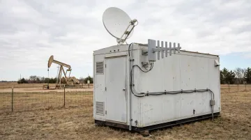 Remote oil and gas facility trailer with Starlink dish and cellular antenna mounted outside
