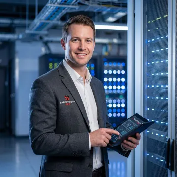 IT professional reviewing colocation infrastructure requirements on tablet in modern data center facility