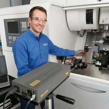 Technician performing ballbar test on CNC machine with Renishaw diagnostic equipment