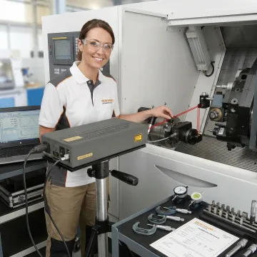 Technician performing precision measurement training on CNC machine