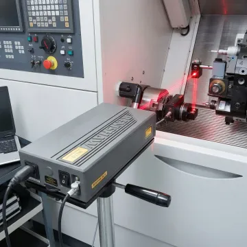Precision laser interferometer testing equipment measuring CNC machine accuracy in a manufacturing facility