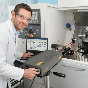 Calibration technician using Renishaw laser system on CNC machine